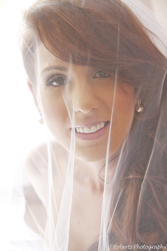 Bride looking up at the camera through her veil - wedding photography sydney